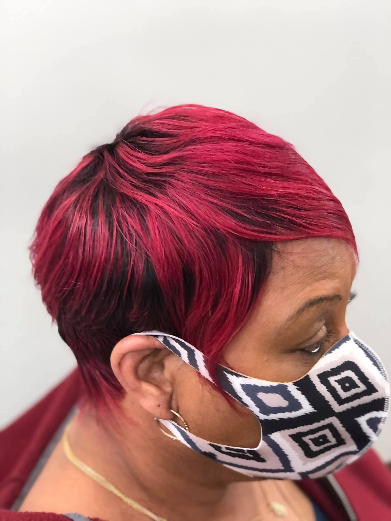 Woman with short red hair and a patterned face mask.