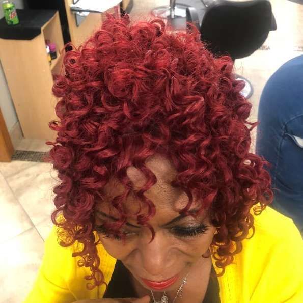 Woman with red curly hair and yellow top.