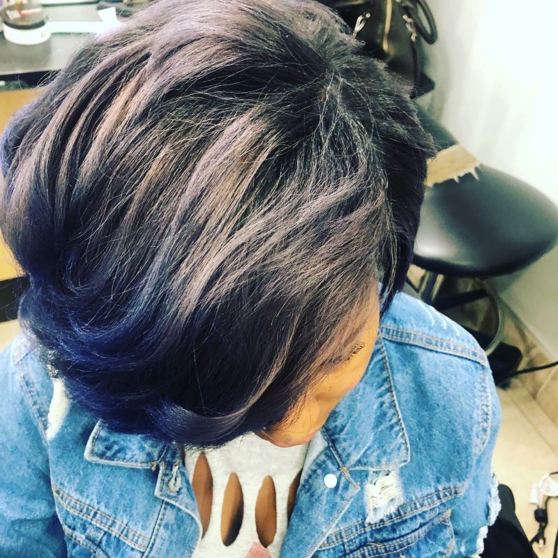 Woman with short, dark hair styled in a bob, with blue and grey highlights.