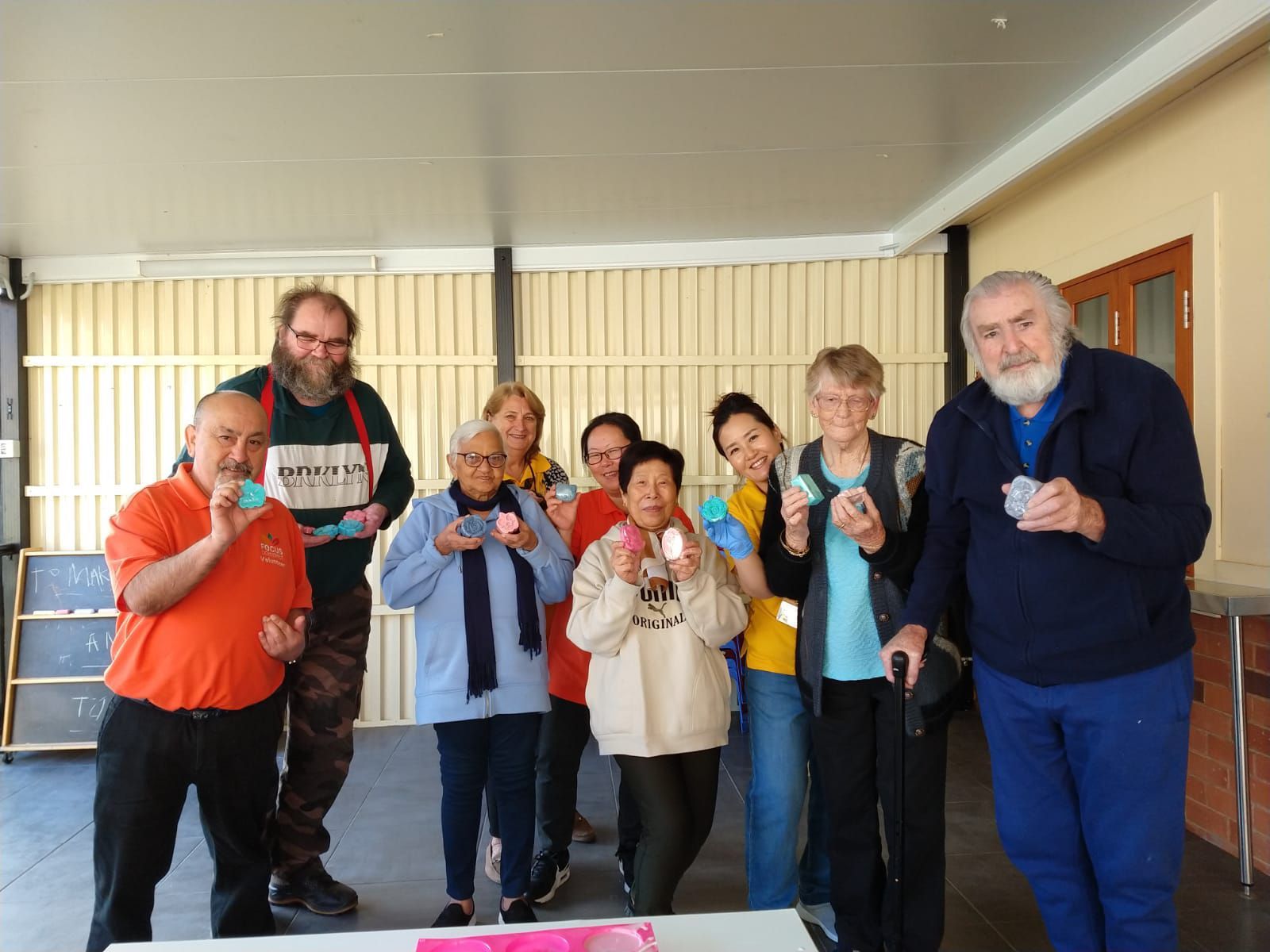 A group of people standing around a table holding cards.