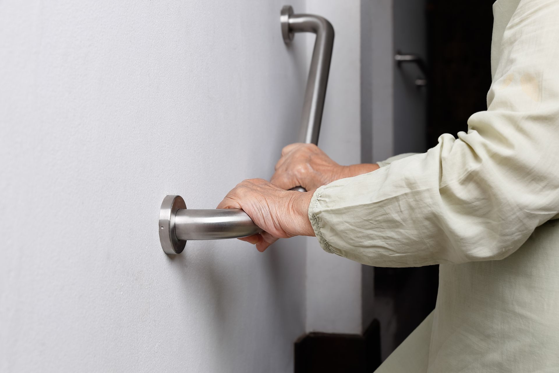 A person is holding onto a handle on a wall.