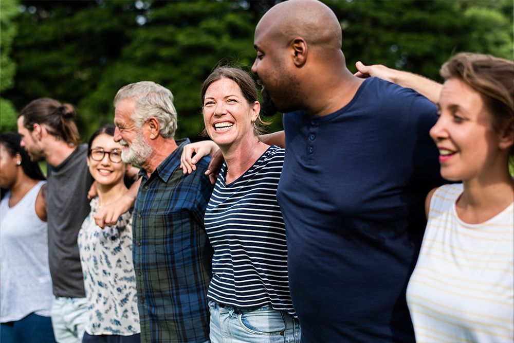 a group of people standing in a line with their arms around each other