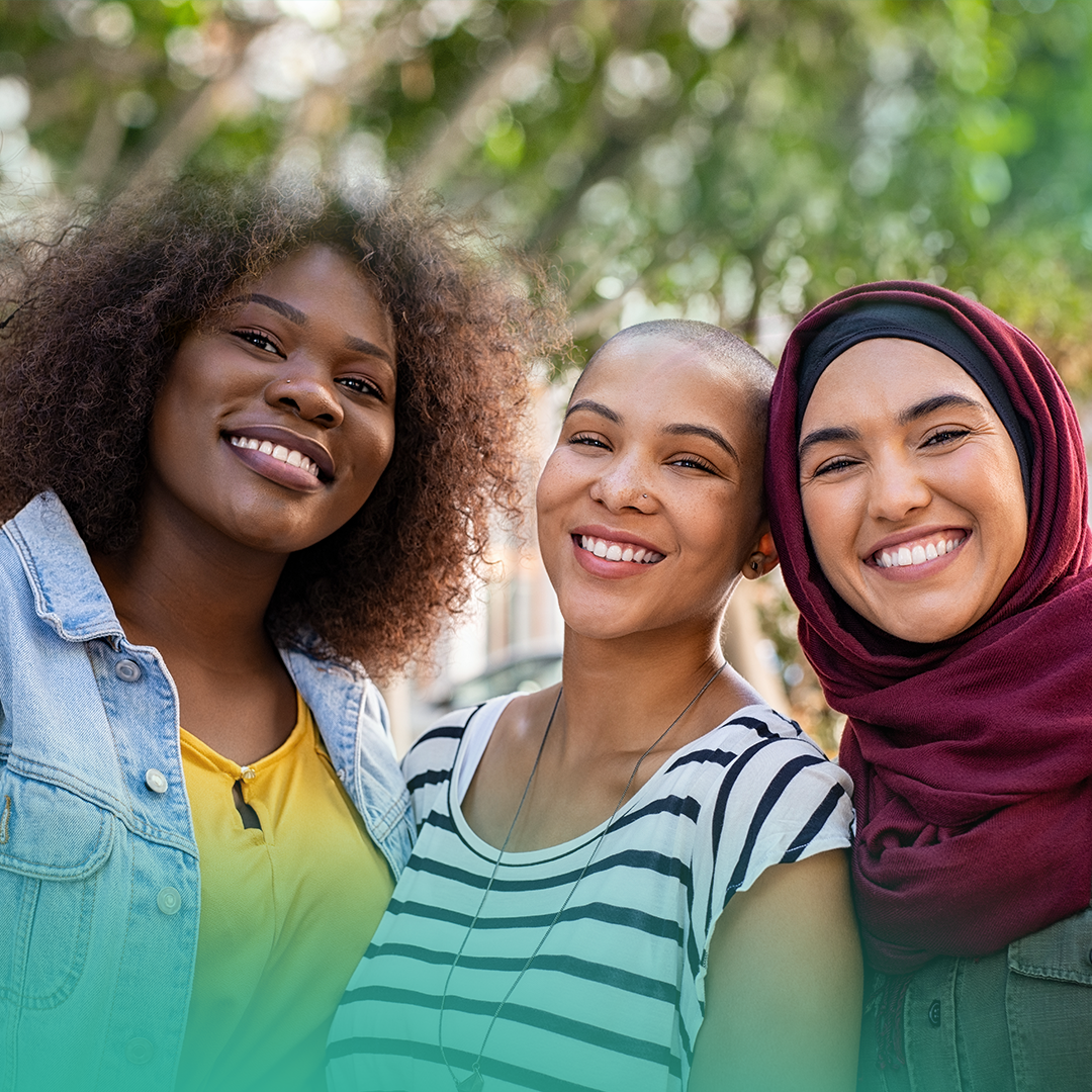 Three women posing for a picture together and smiling.