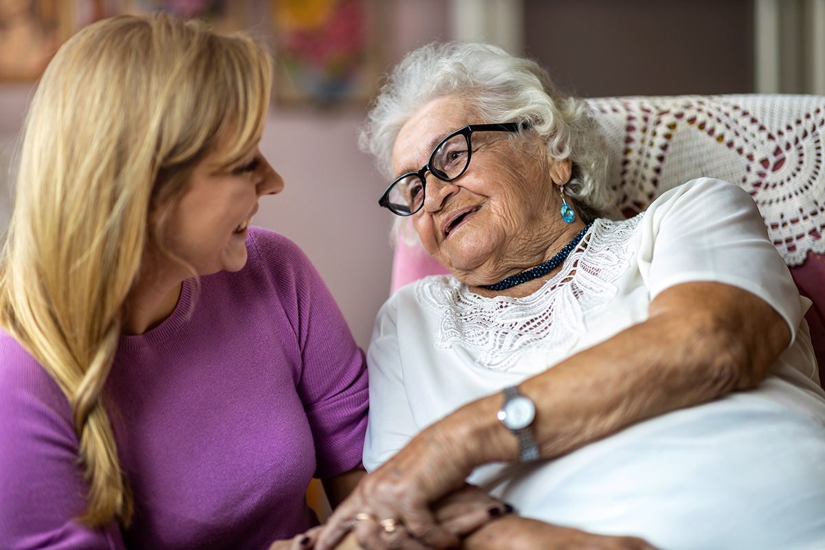 A carer reassuring her elderly patient.