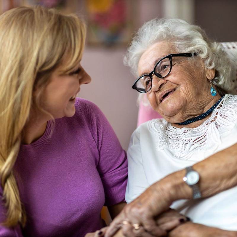 A carer reassuring her elderly patient.