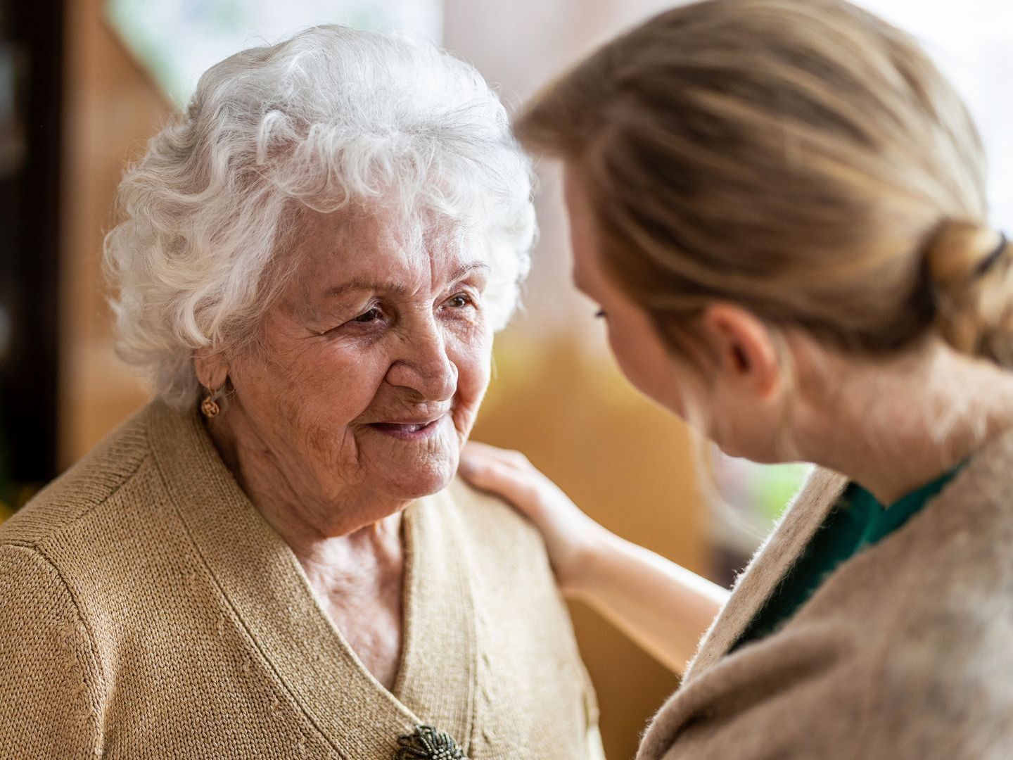 A carer reassuring an elderly patient.