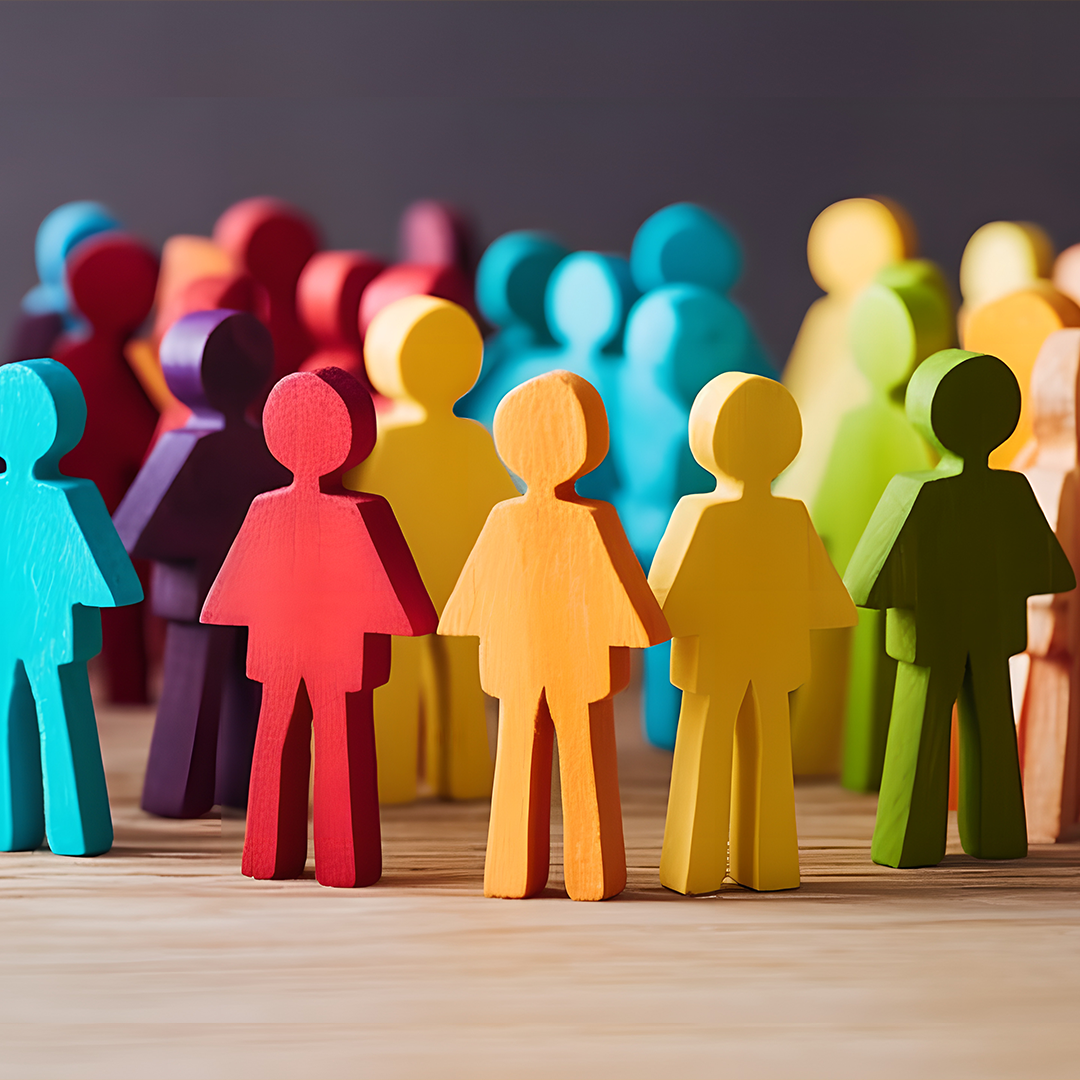 A group of colourful wooden people standing next to each other.