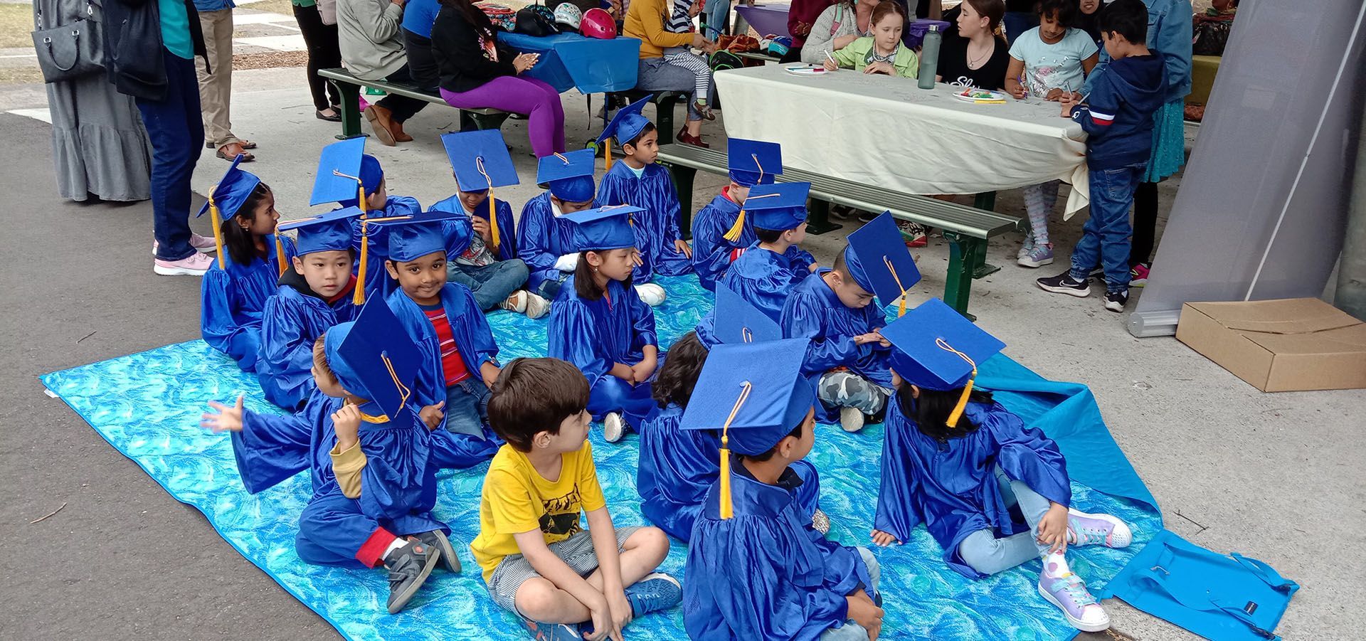 Children wearing a blue graduation robe