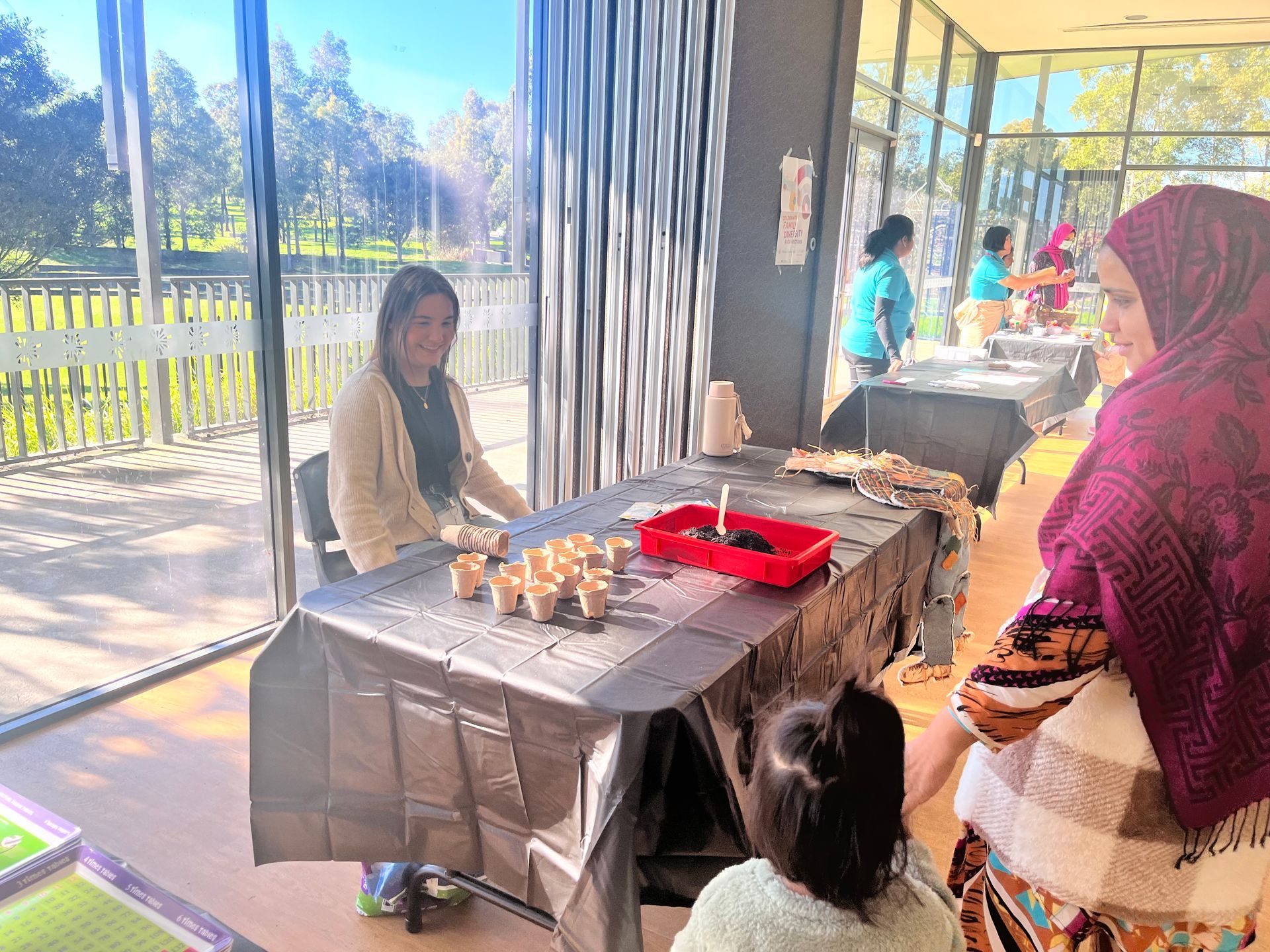 A woman in a hijab with a child interacting with another woman