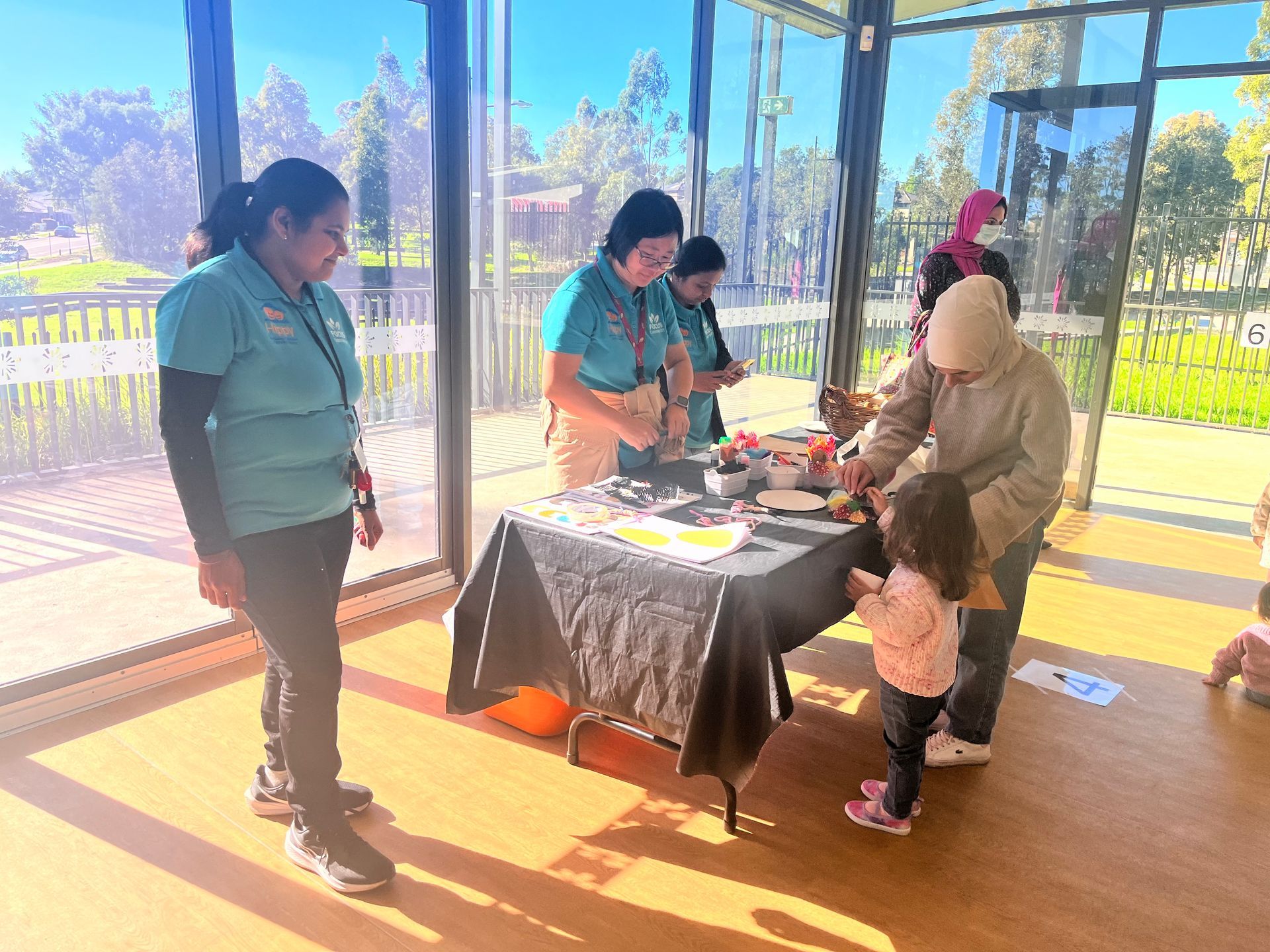 people standing around a table in a sunlit room