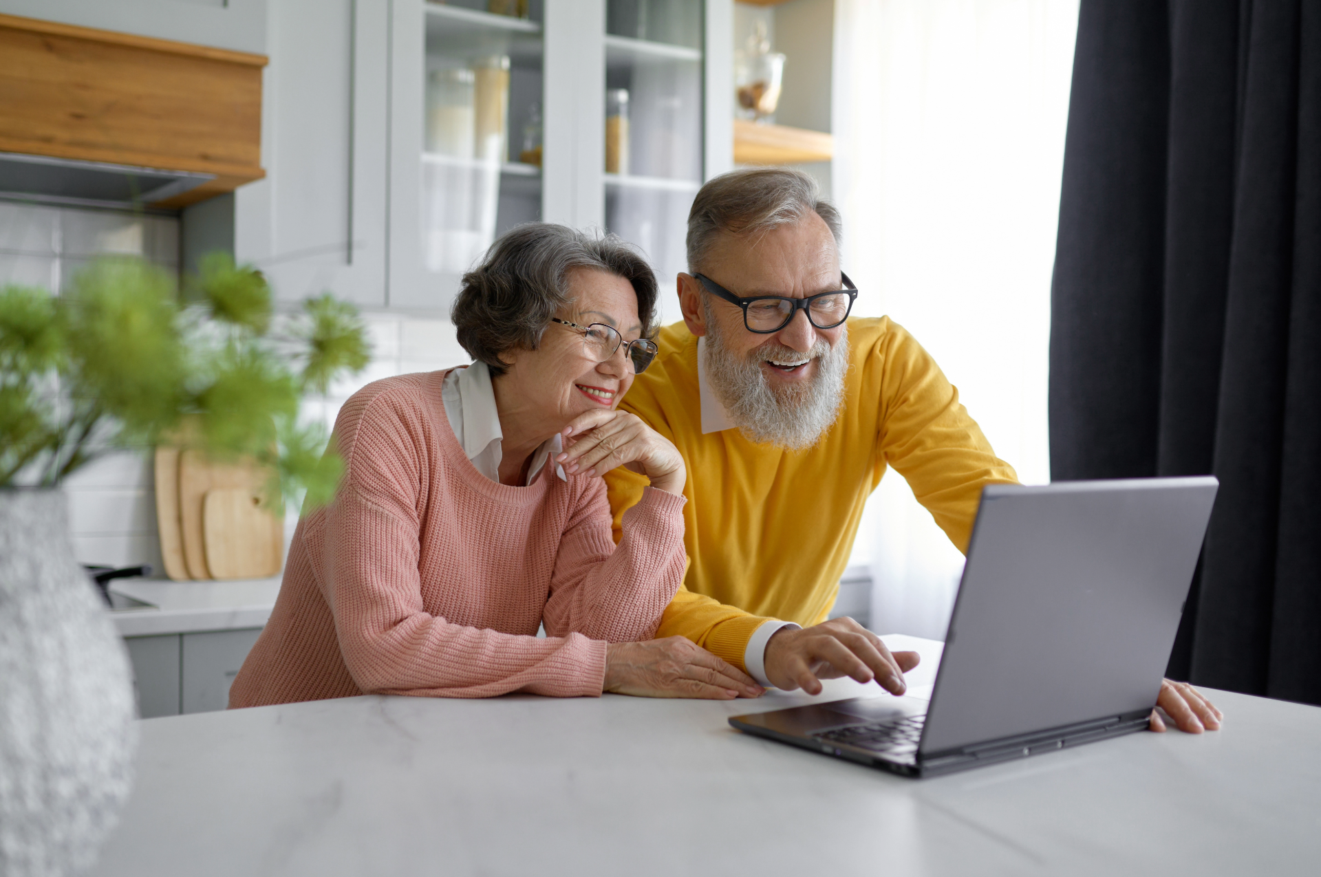 Older couple using a laptop at home, applying for NSW seniors cards.