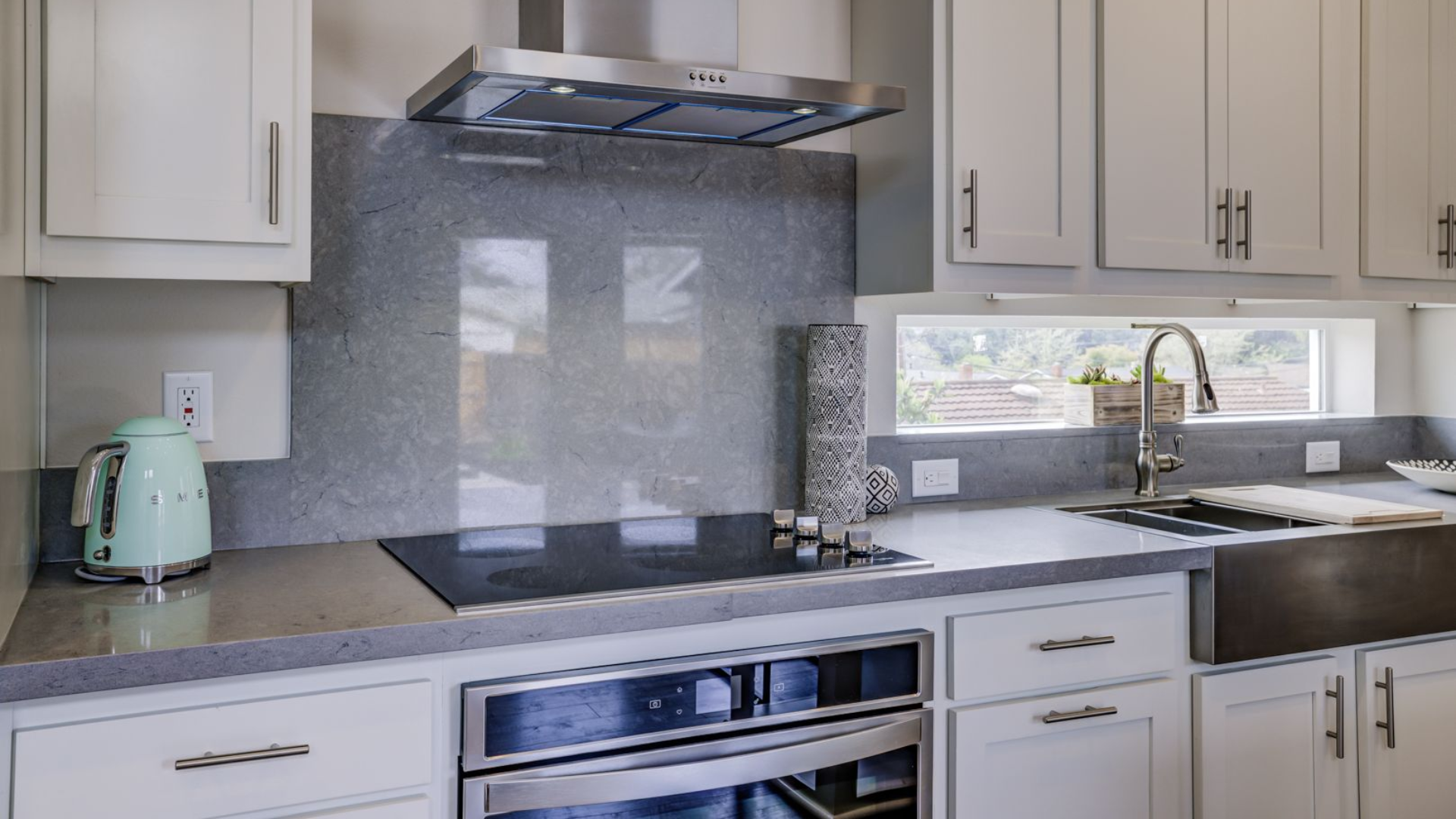 Perpetual Homes ADU: Modern kitchen with light gray cabinets, stainless steel appliances, and gray countertop.