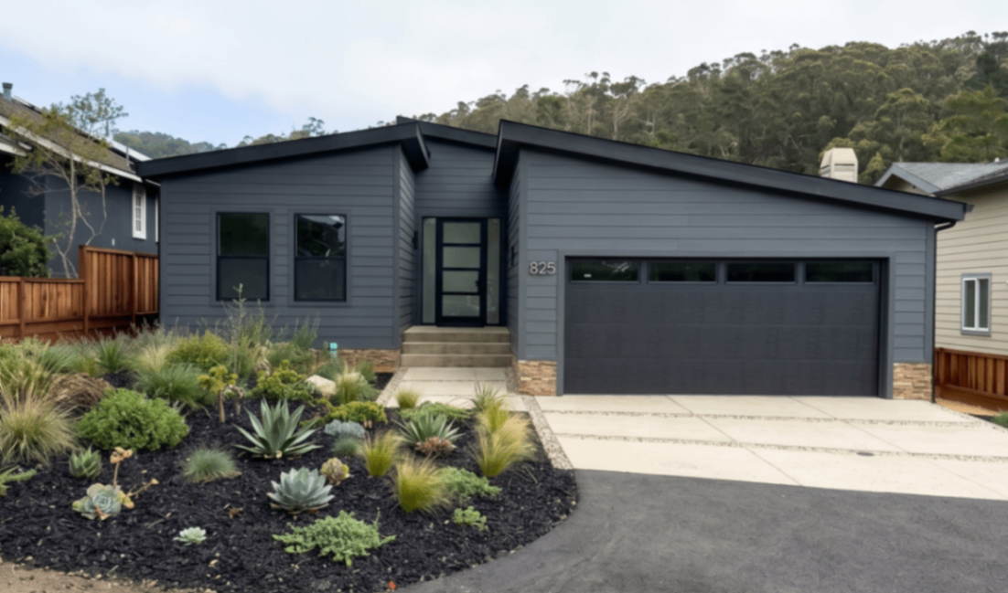 Carlsbad design from Perpetual Homes a modern, dark grey single-story house with a garage.