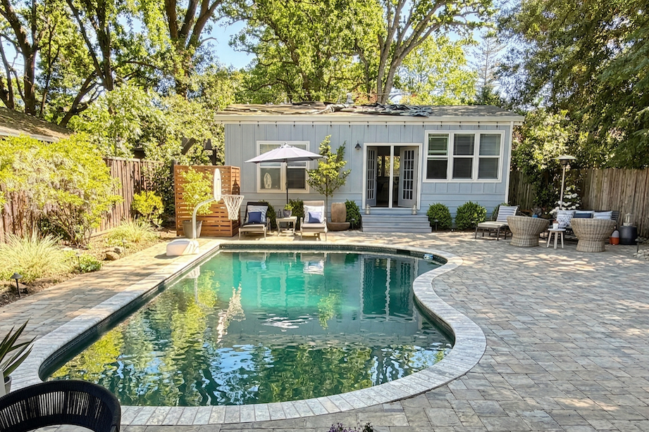 A backyard patio with a pool featuring the Claremont ADU from Perpetual Homes.