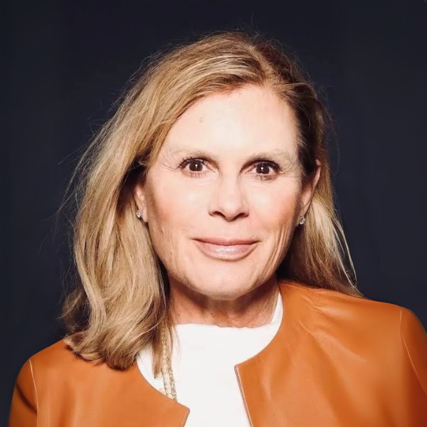 Katherine Anderson, Perpetual Homes ADU: Woman with blonde hair wearing a white shirt and orange jacket smiling.