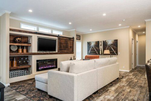 Livingroom with a Sectional and Fireplace under T.V.