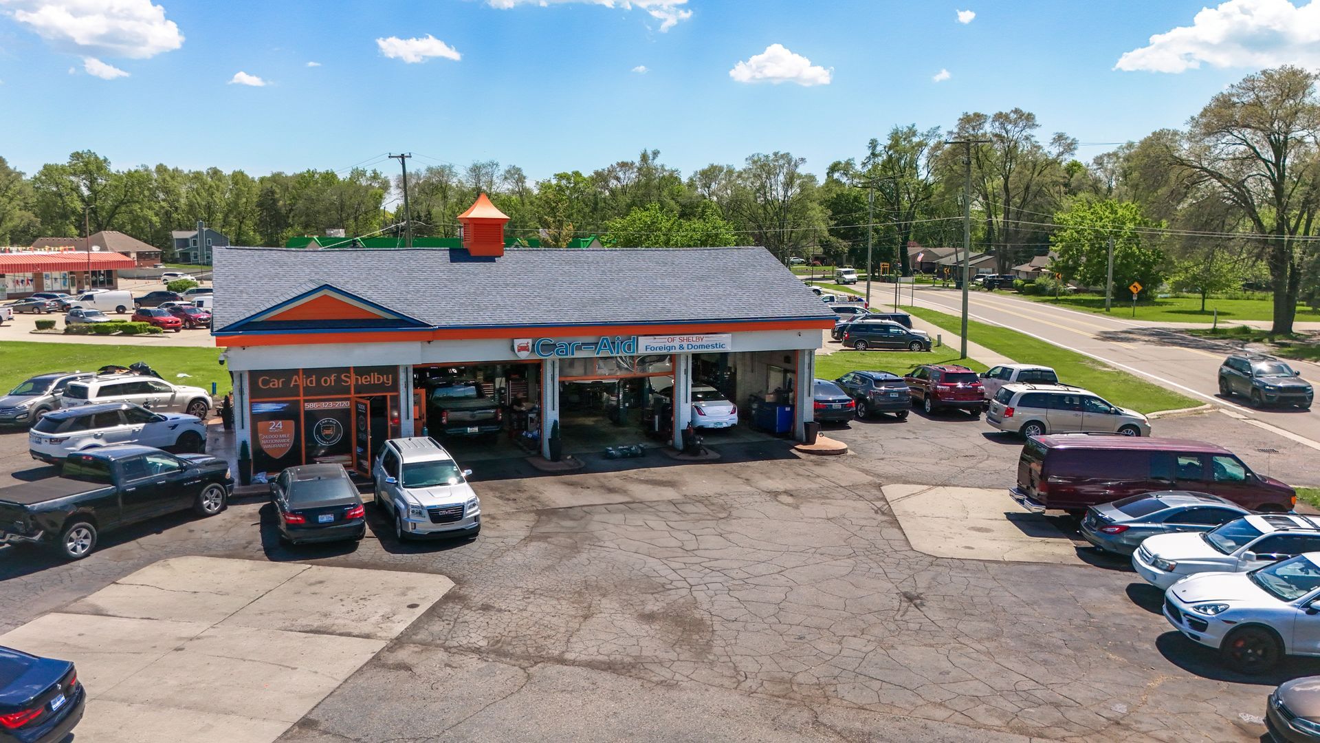 A lot of cars are parked in front of a car wash.