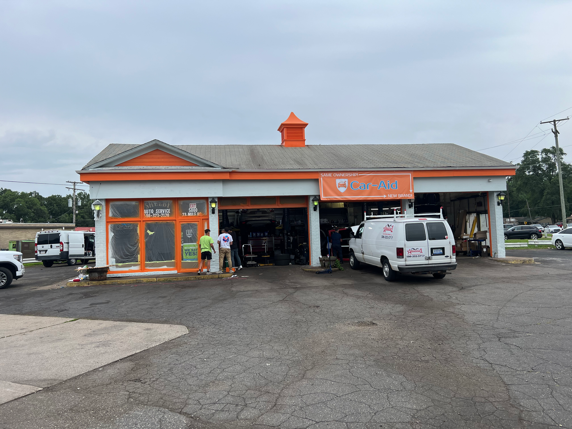 A white van is parked in front of a gas station.