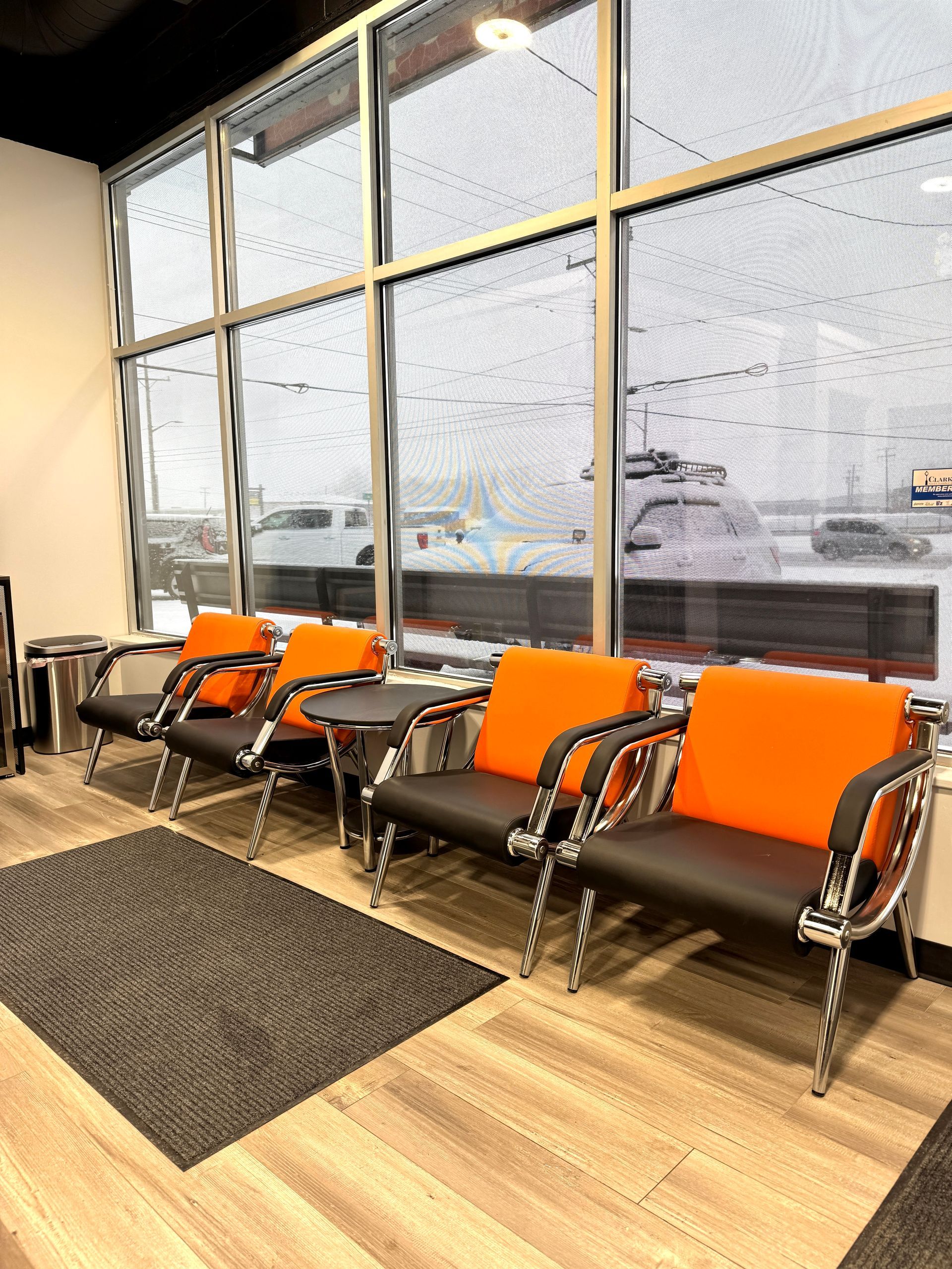 A row of chairs in a waiting room with large windows.
