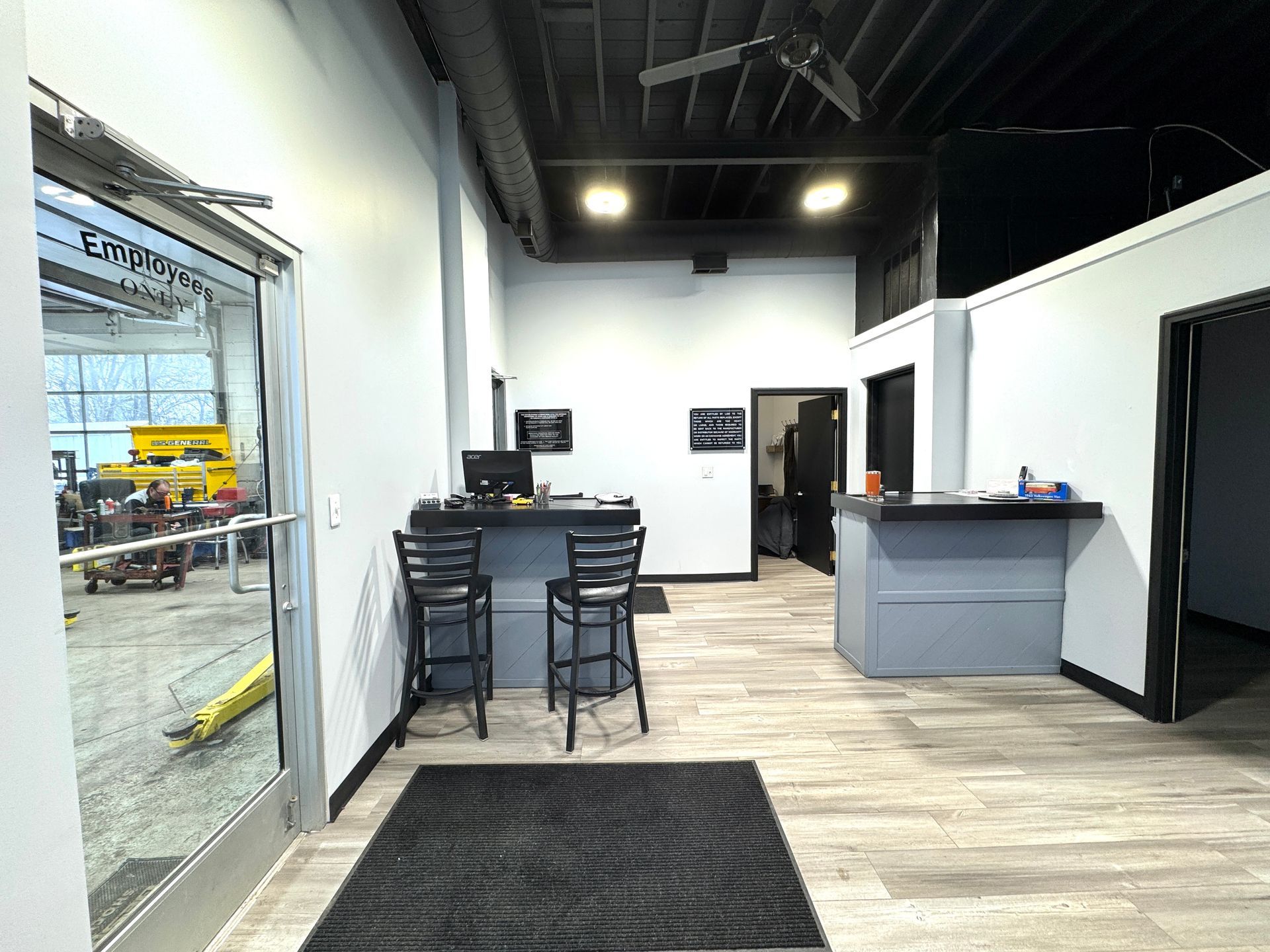 A large room with a counter and stools in it.