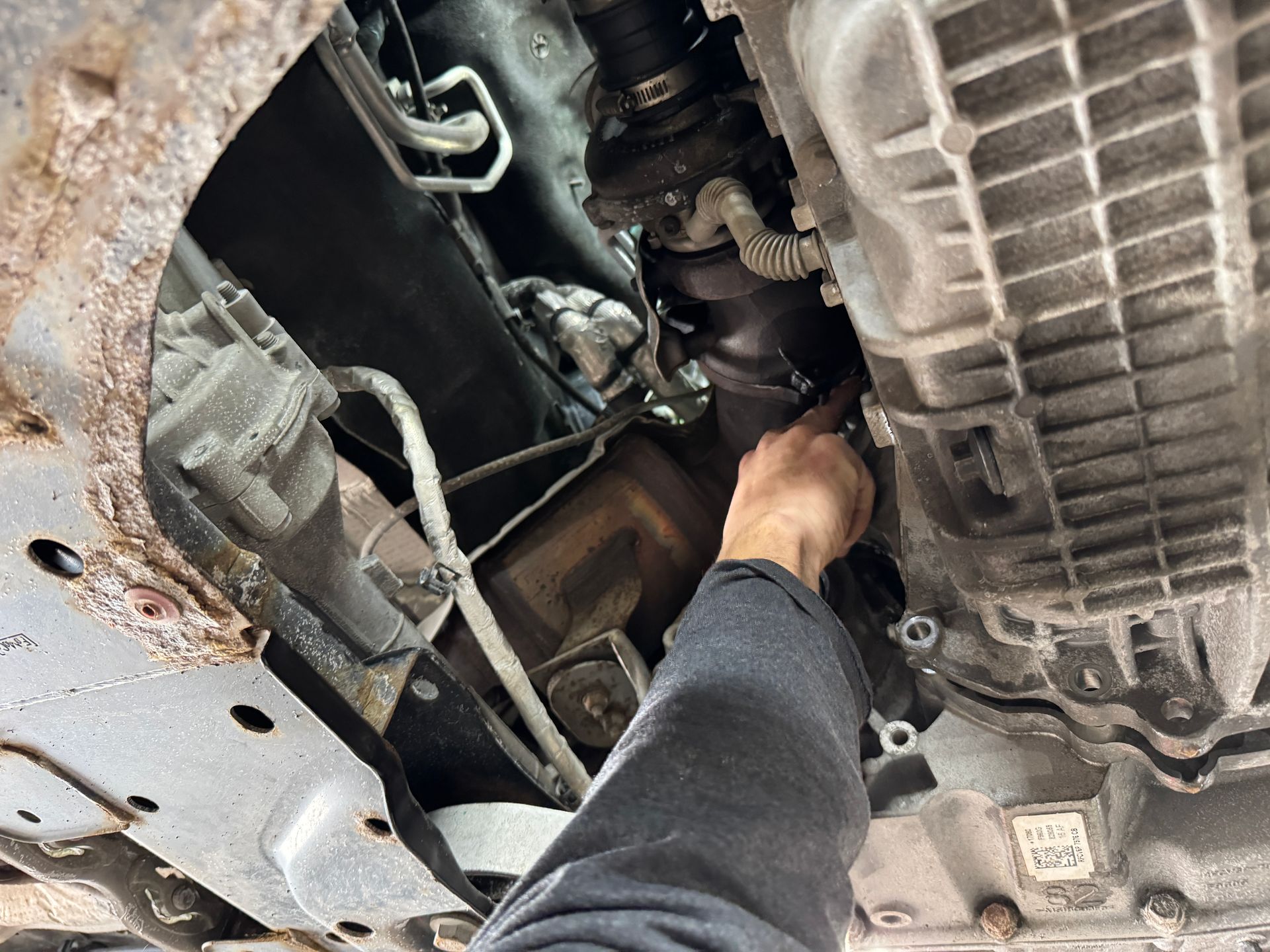 A person is working on the underside of a car.