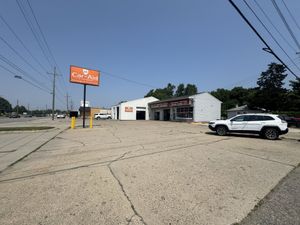 A car is parked in front of a car aid store.