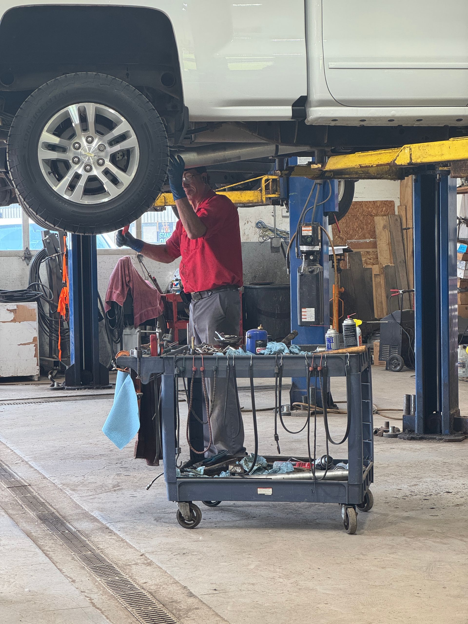 guy standing underneath car to fix it 