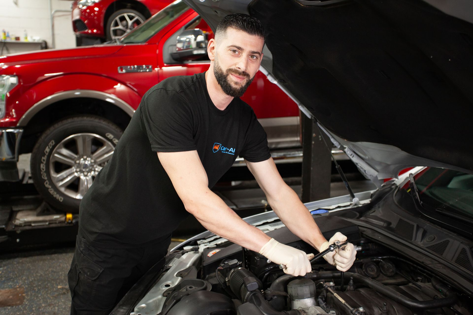 A man is working under the hood of a car.