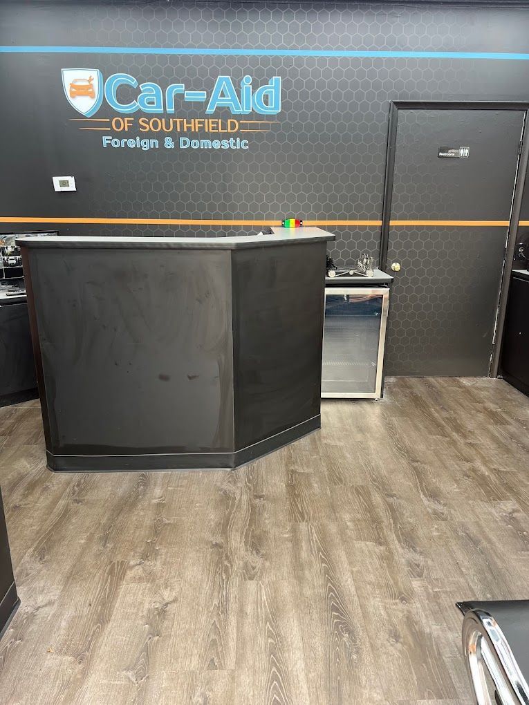 A black counter in a room with a sign on the wall that says `` car aid ''.