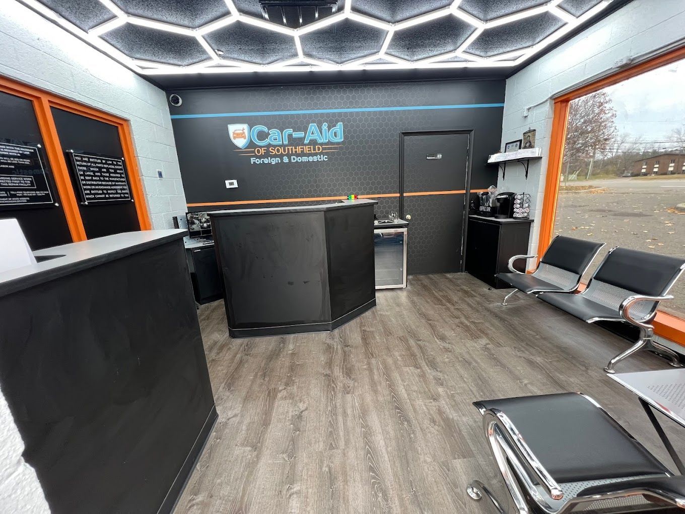 A waiting room with a counter , chairs , and a window.