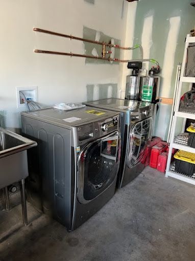 A laundry room with a washer and dryer and a sink.