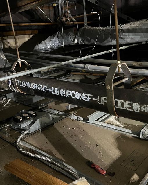 A bunch of pipes are hanging from the ceiling of a building.
