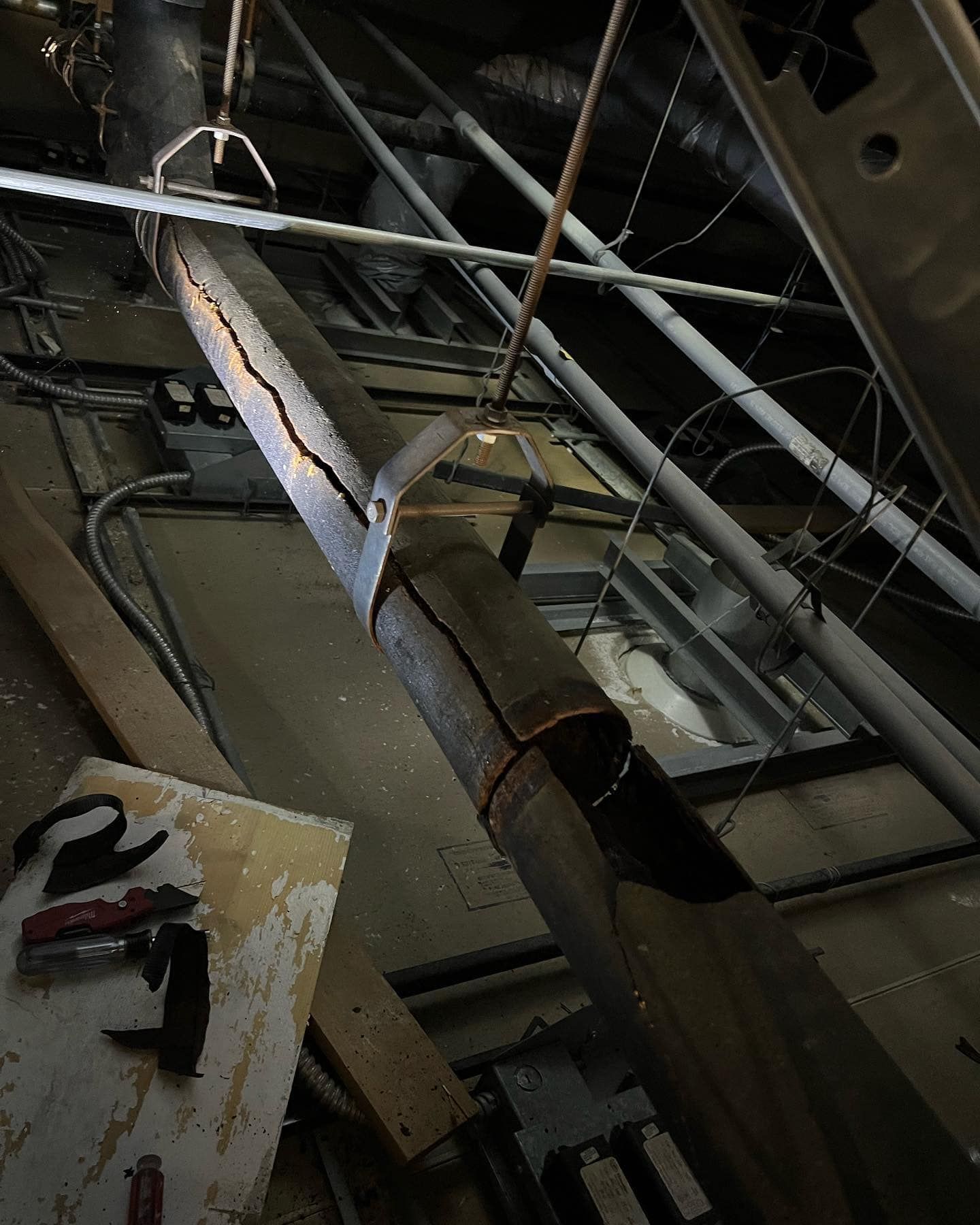 A metal pipe is hanging from the ceiling of a building