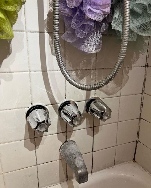 A bathtub with a shower head attached to it