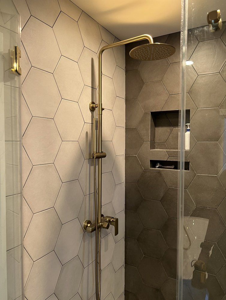 A shower with a shower head and a glass door