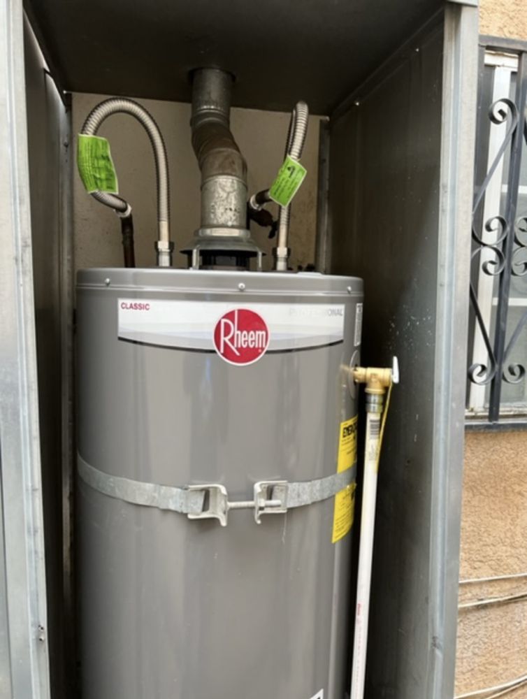 A rheem water heater is sitting inside of a metal box.