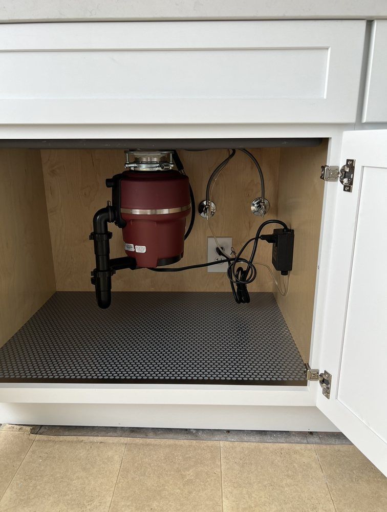 A garbage disposal is sitting under a kitchen sink.