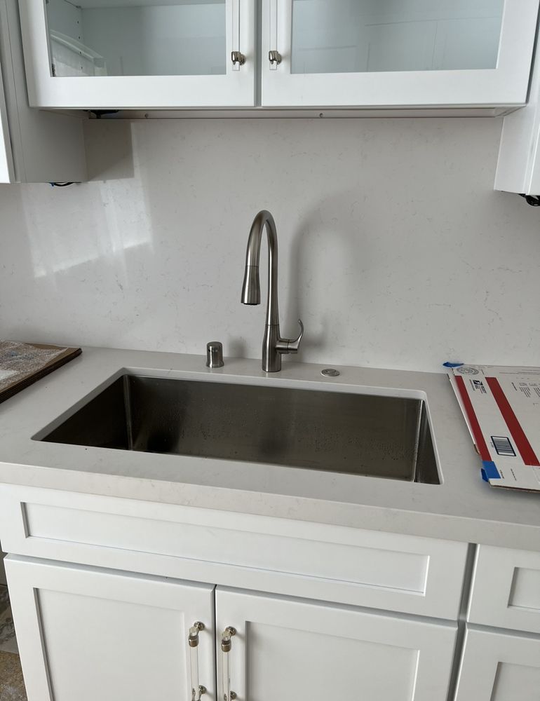 A kitchen with a stainless steel sink and a faucet