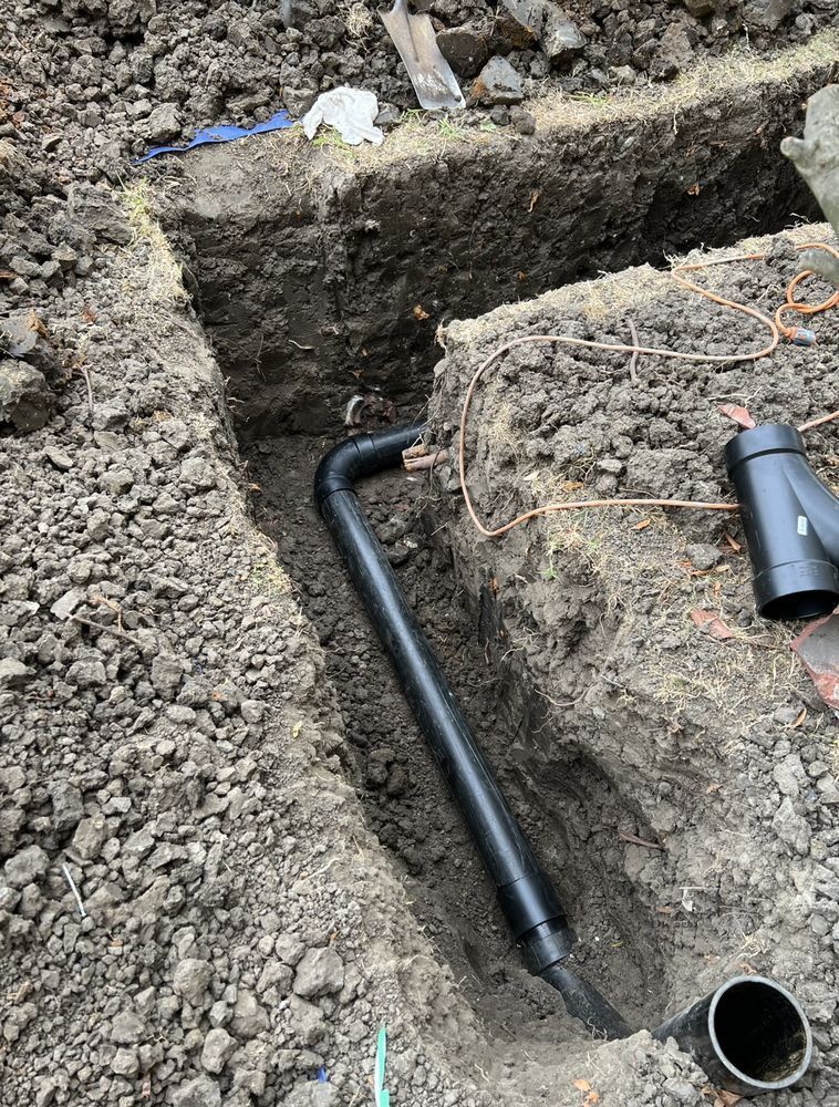 A pipe is being installed in a hole in the ground.