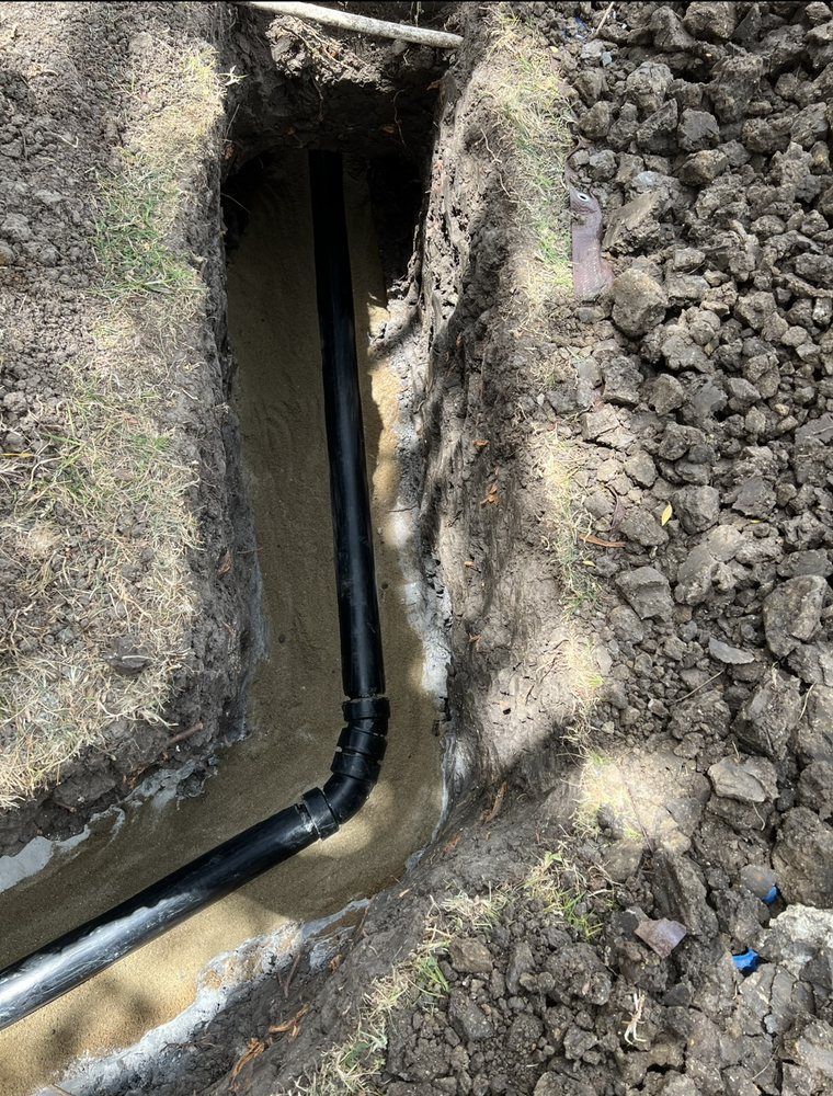 A pipe is being installed in a hole in the ground.