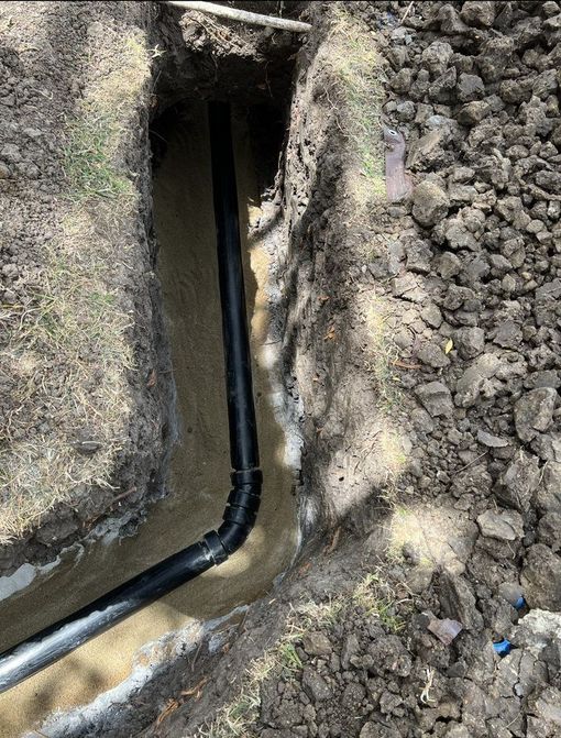 A pipe is being installed in a hole in the ground.