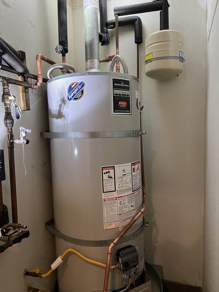 A water heater is sitting in a room next to a wall.