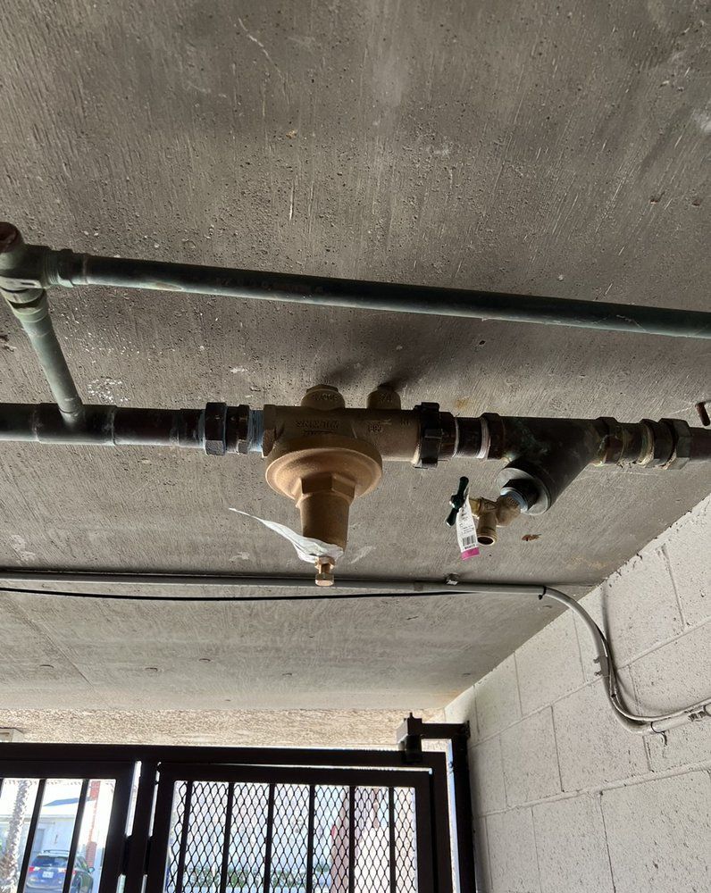 A bunch of pipes are hanging from the ceiling of a building.