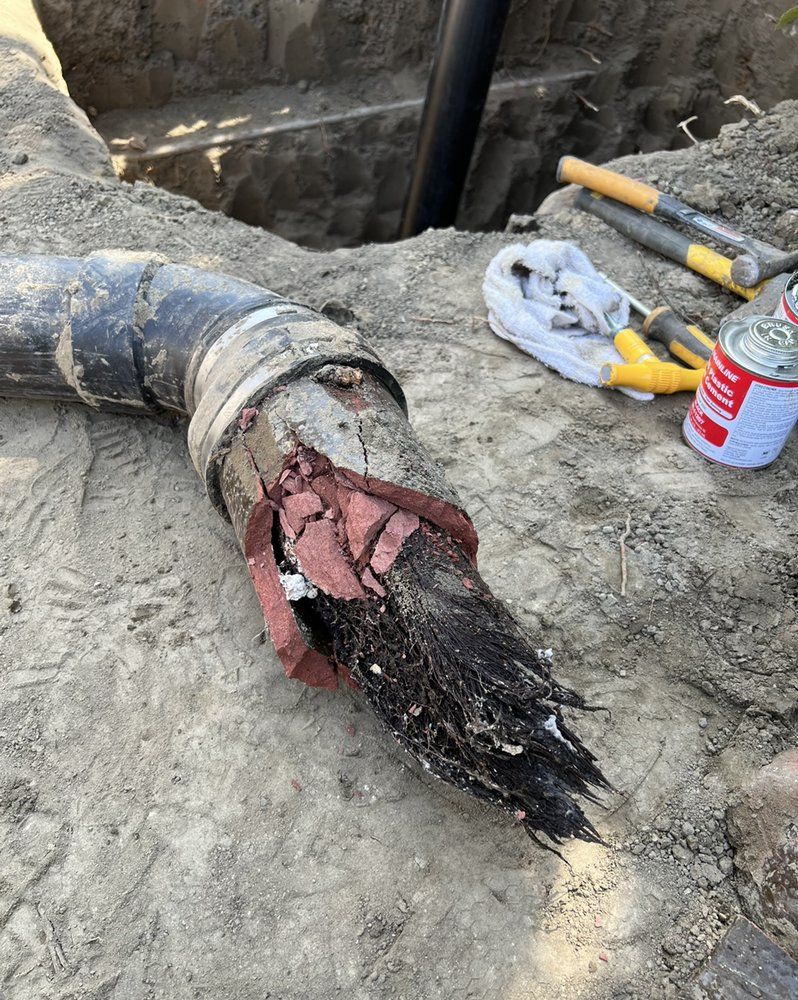 A broken pipe is laying on the ground next to a can of spray.