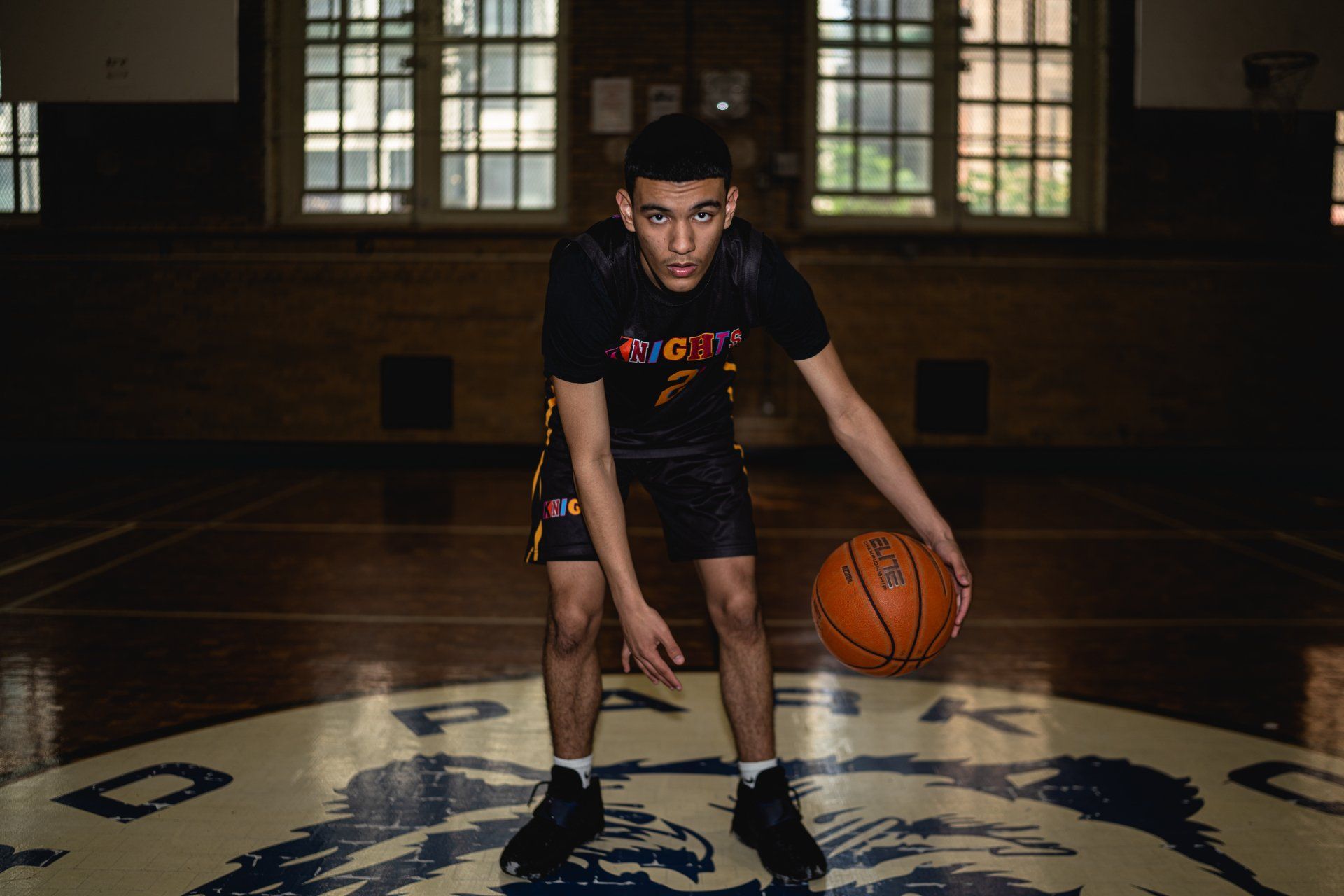 Member of the the New Design High School Knights basketball team dribbles