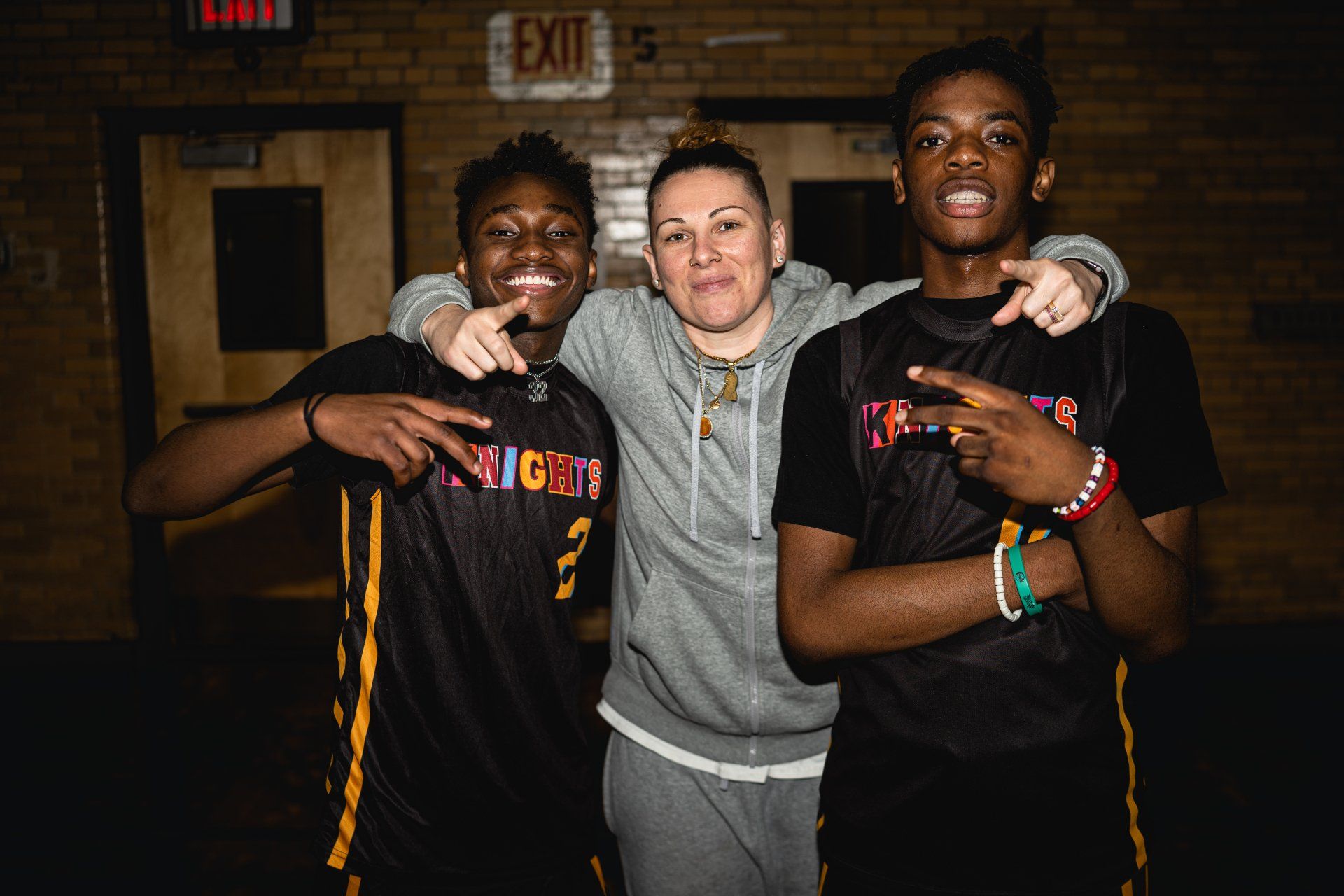 Coach Katey poses with members of the New Design Knights basketball team