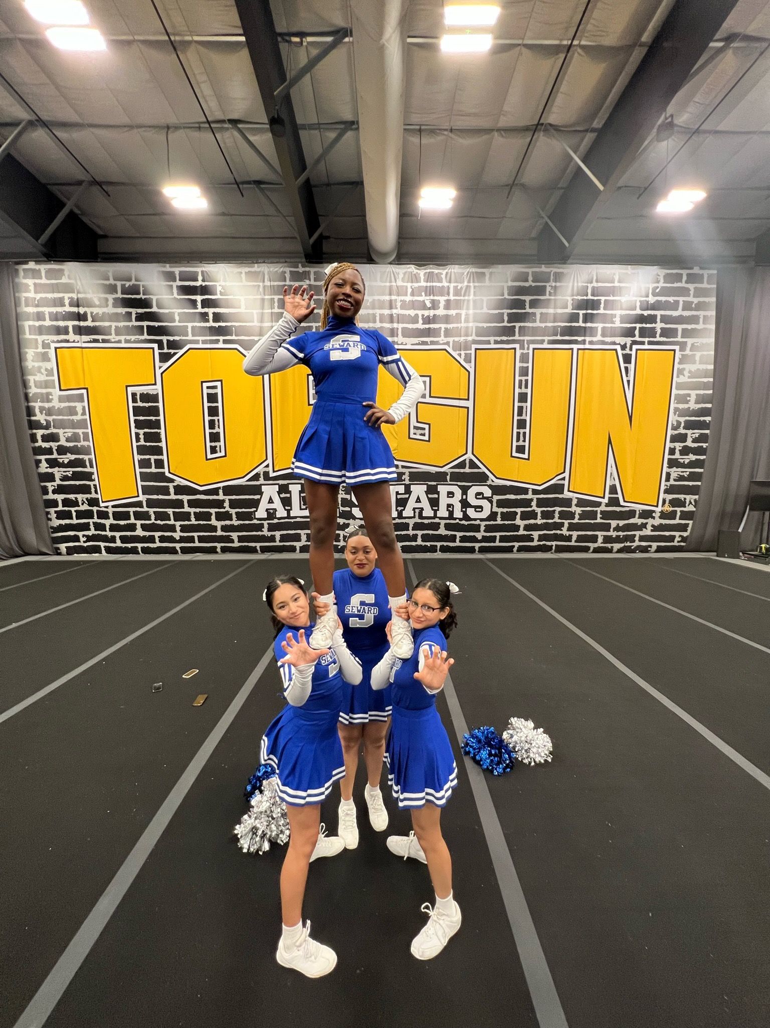 Cheerleaders doing pyramid stunt at Top Gun gym