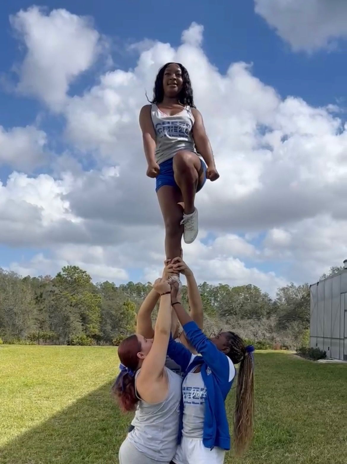 Cheerleaders practicing pyramid stunt