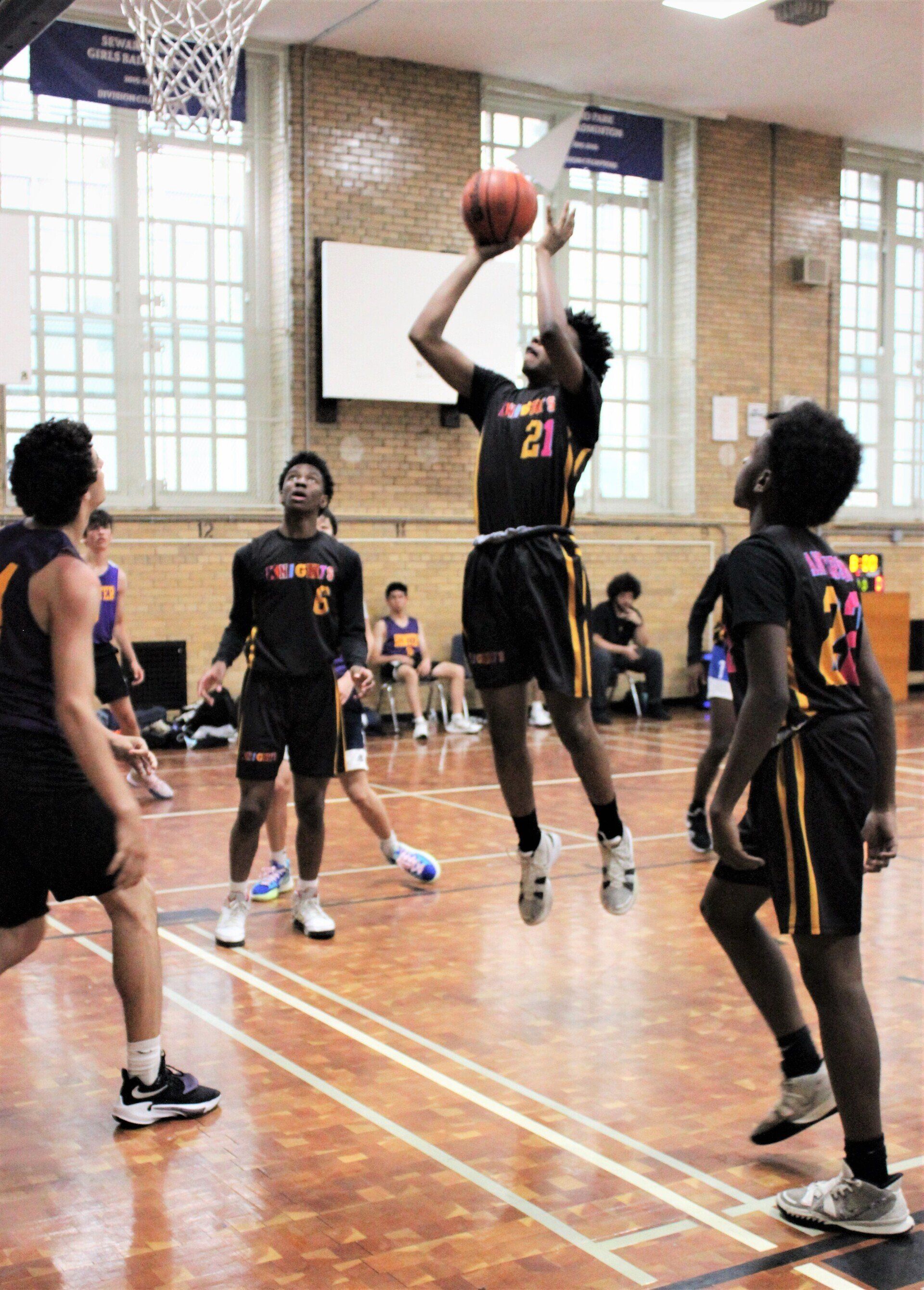Members of the New Design Knights play basketball