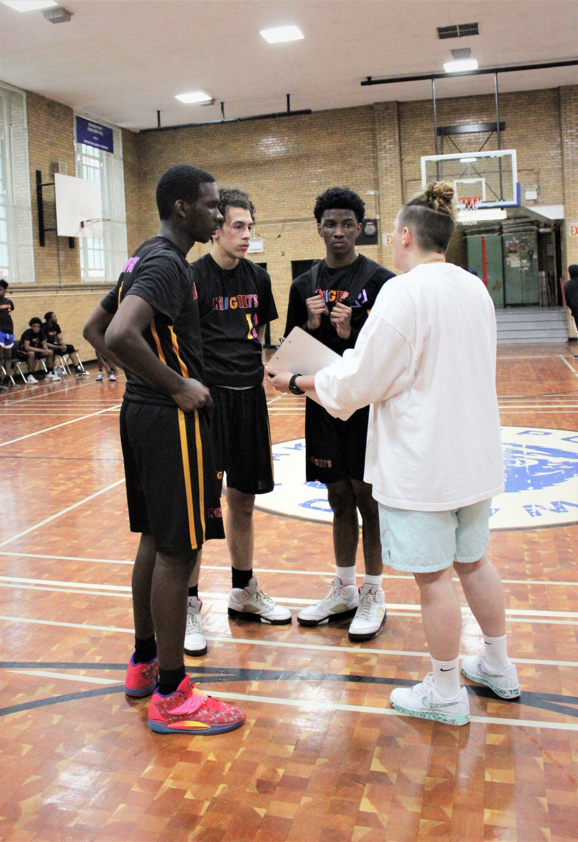 Coach Katey speaks to members of the New Design Knights basketball team